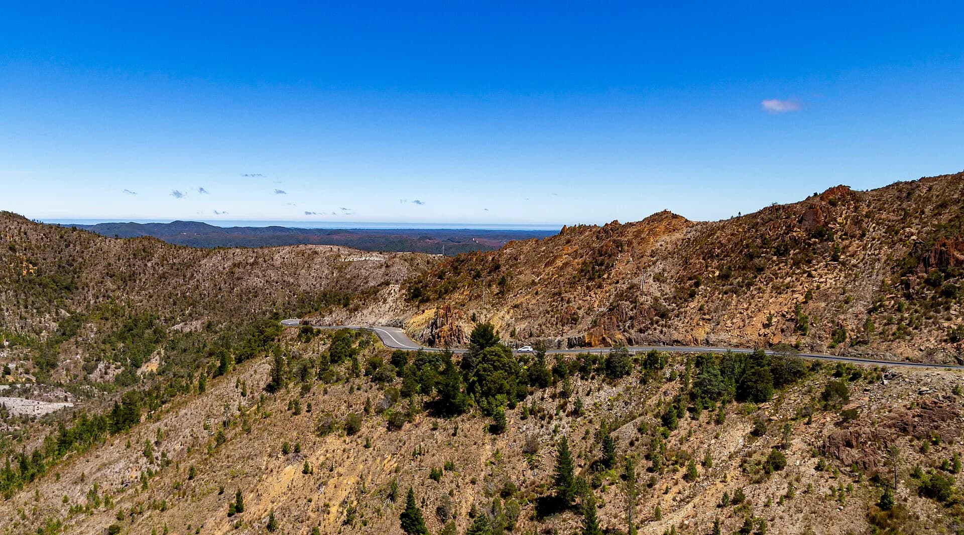 Remote west-coast road crossing forested country