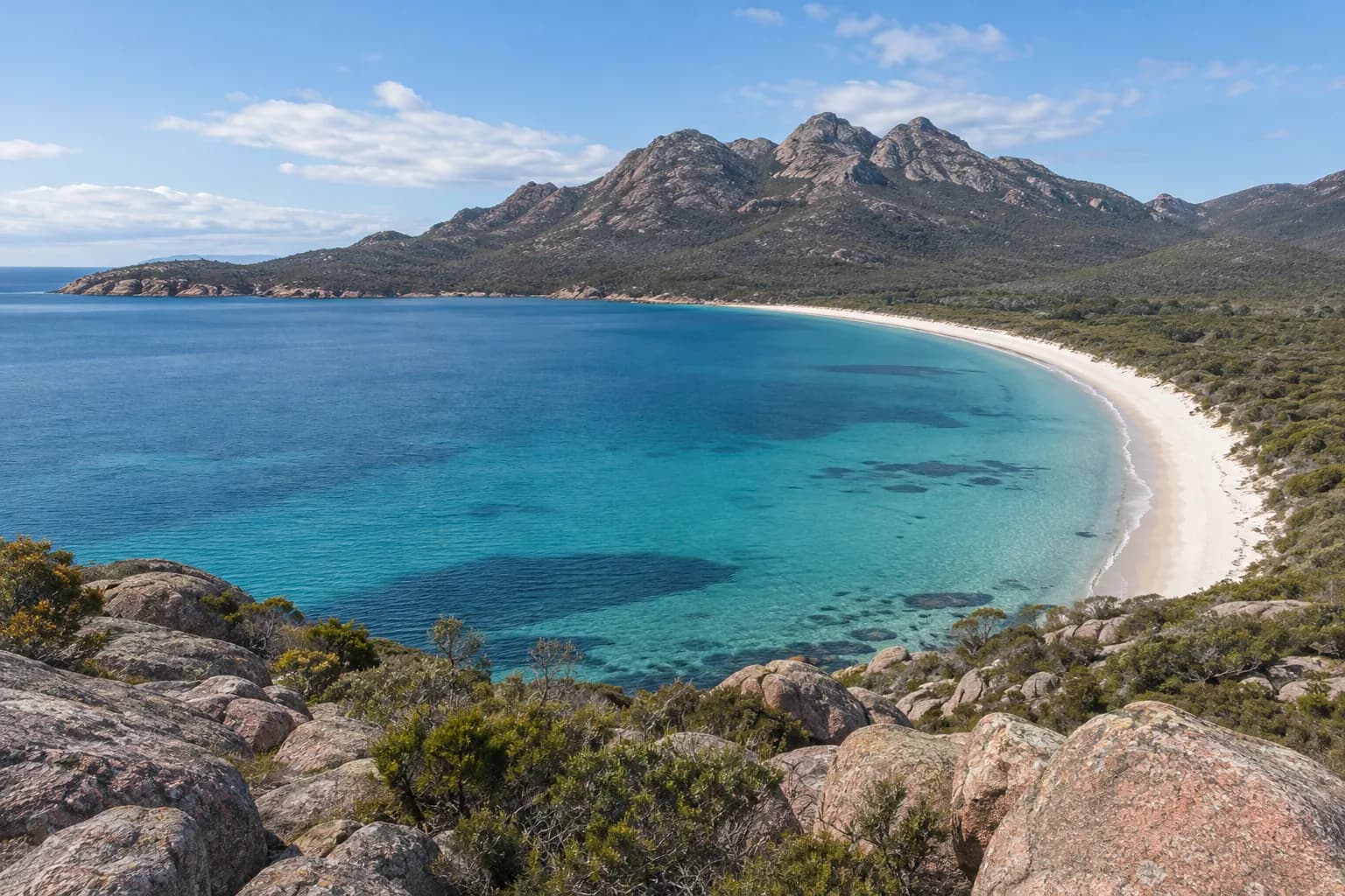A curved white beach and granite mountains on Tasmania’s east coast